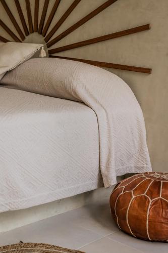 a bed with a white comforter and a pillow at La Bohème Sayulita in Sayulita