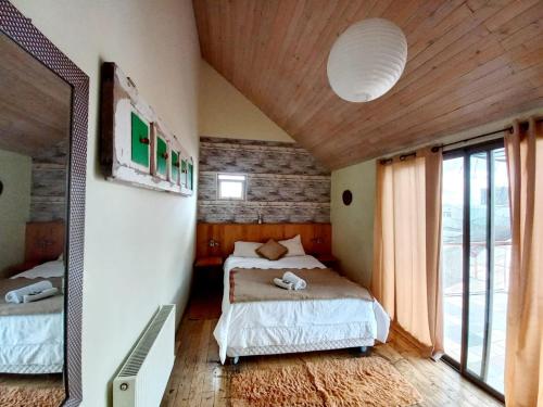 a bedroom with two beds and a mirror in it at Hotel Nativo in Santiago