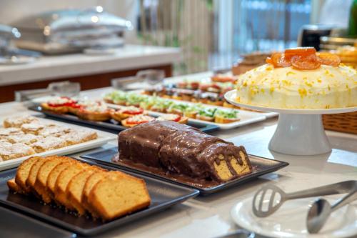 ein Buffet mit verschiedenen Desserts und Kuchen in der Unterkunft B4B Athens Signature Hotel in Athen