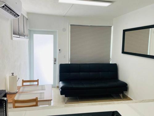 a living room with a black couch and a table at Hollywood Apartments - C in Yabucoa