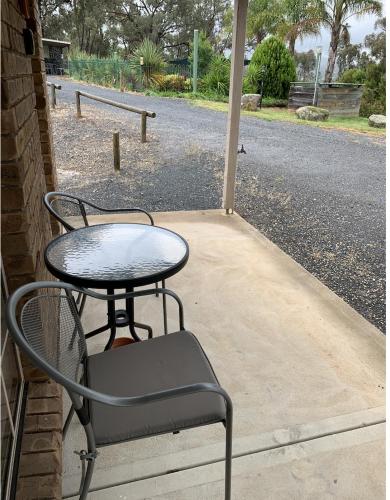a table and a chair sitting on a patio at Motel Views Yackandandah in Yackandandah
