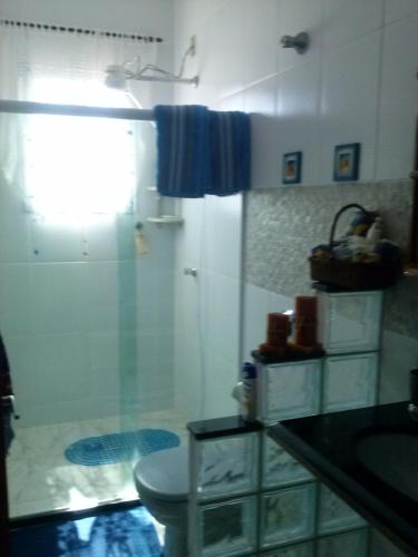a bathroom with a shower and a sink and a toilet at Apartamento Piúma in Piúma