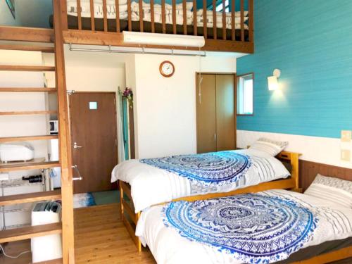 2 camas en una habitación con paredes azules en ALOALO BEACH 川平, en Fukai