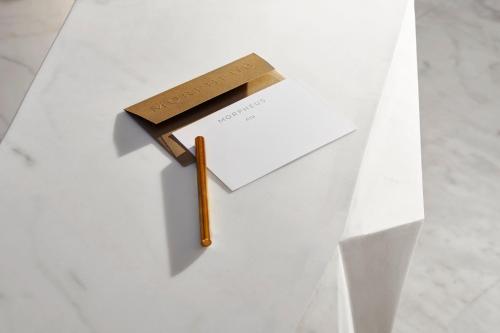a white table with an envelope and a wooden stick at City of Dreams - Morpheus in Macau
