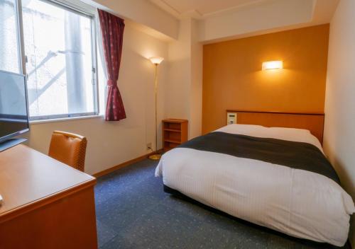 Postel nebo postele na pokoji v ubytování APA Hotel Miyazaki Nobeoka Ekimae