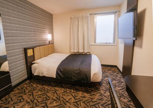 מיטה או מיטות בחדר ב-APA Hotel Miyazaki Nobeoka Ekimae