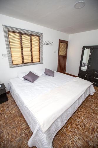 KOMODO ALOJAMIENTO- hostal autoservicio, ubicado cerca al centro - baño privado, wifi , cama 2x2 y agua caliente y cocina compartidaにあるベッド