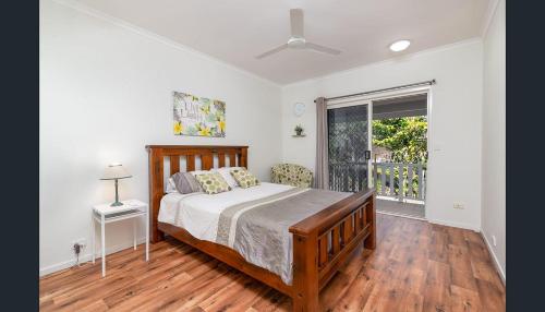 a bedroom with a bed and a large window at Entire 2 bedroom townhouse - Four Mile Beach Escapes - your home away from home in Port Douglas