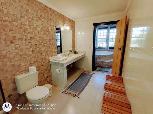 ein Badezimmer mit einem WC, einem Waschbecken und einer Badewanne in der Unterkunft Tiradentes Pousada Ramalhete in Tiradentes