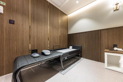 a hospital room with a bed and a cross on the wall at Hotel Lium in Cheonan