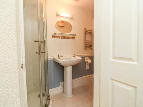 a bathroom with a sink and a mirror at Claire's Cottage in Poughill