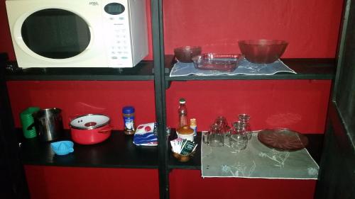 eine Küche mit einer Mikrowelle und einem Regal mit Lebensmitteln in der Unterkunft Terraza a las sierras in Río Ceballos
