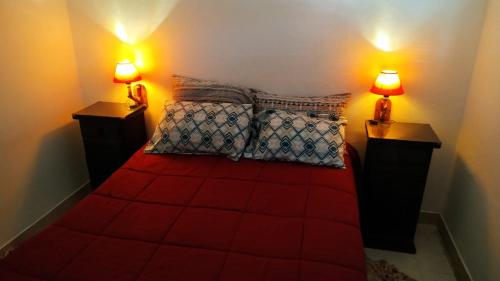a bedroom with a red bed with two lamps at Perlas del Mar in Puerto Madryn