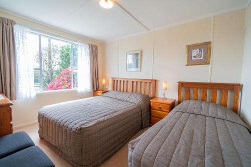 蒂阿瑙的住宿－Rustlein Cottage - Te Anau Holiday Home，一间卧室设有两张床和窗户。