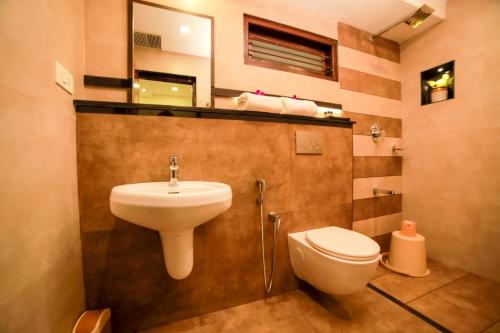 a bathroom with a sink and a toilet at Golden Fern Resort in Kanthalloor