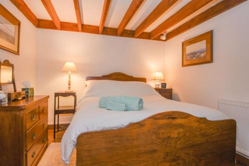 a bedroom with a large bed with a wooden headboard at Townend Barn in Lydford