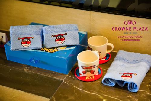 a table with two cups and a box with towels at Crowne Plaza Guangzhou Huadu by IHG - Free Shuttle bus between hotel to Exhibition Center During Canton Fair in Guangzhou