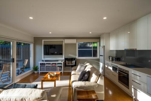 a kitchen and living room with a couch and a table at Cod Rock Point in Bicheno