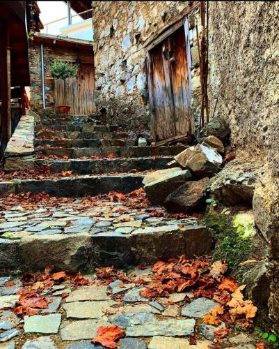 a stone building with stairs and a wooden door at Sophias Cottage in Askas