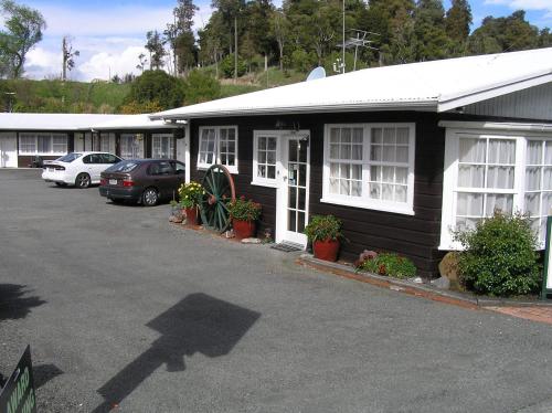 a black building with white windows and a parking lot at Coachman Motel in Taihape