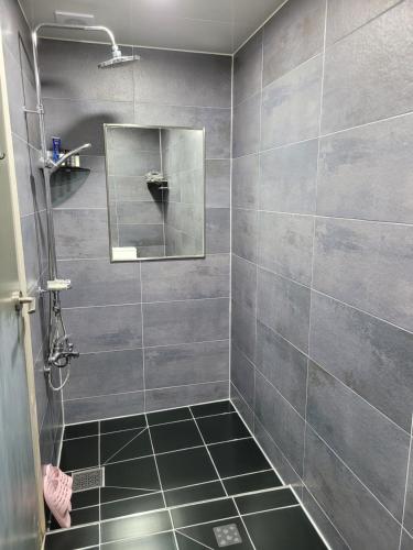 een badkamer met een douche en een spiegel bij Magenta in Donghae