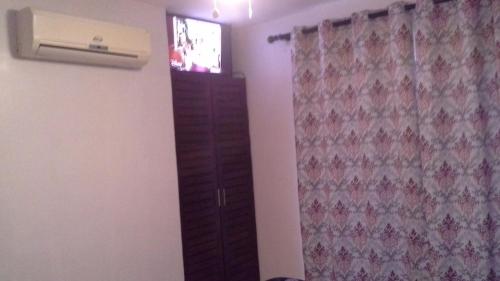 a room with a television and a dresser with a window at Nice condo for vacation in playas del coco in Coco