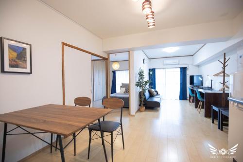 a living room with a dining room table and a bedroom at Gentry Hakata in Fukuoka