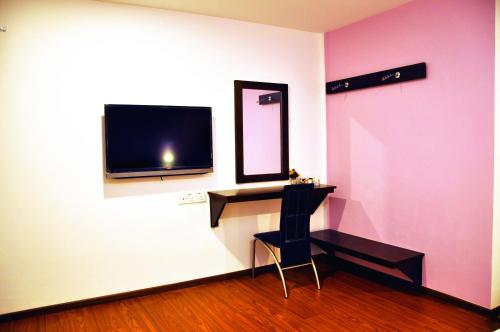 a room with a desk and a tv on a wall at D'View Hotel in Kuala Perlis