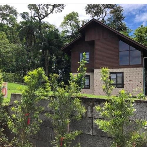 a house with trees in front of it at Casa de campo Rosa dos ventos in Rodeio