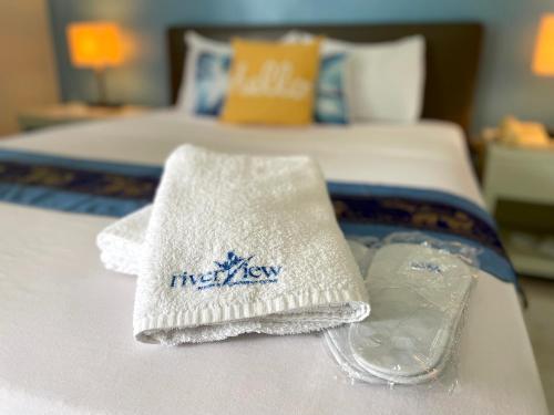 a bed with two towels and a tray on it at Riverview Resort and Conference Center in Calamba
