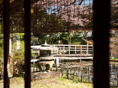 a view from a window of a garden with a fountain at Nanten-En in Kawachinagano