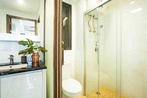 een badkamer met een douche, een toilet en een wastafel bij NOCHE - 2 bedroom Skyhouse Apartment BSD in Tangerang