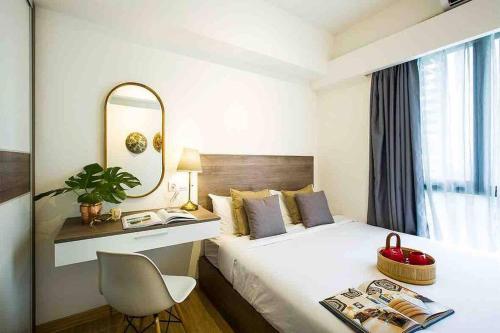 a hotel room with a bed with a desk and a mirror at NOCHE - 2 bedroom Skyhouse Apartment BSD in Tangerang