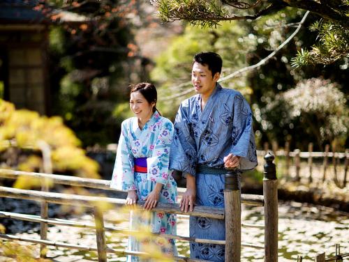 a man and a woman standing next to a fence at Nanten-En in Kawachinagano