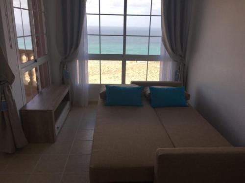 a living room with a couch in front of a window at Sunshine in Costa Calma