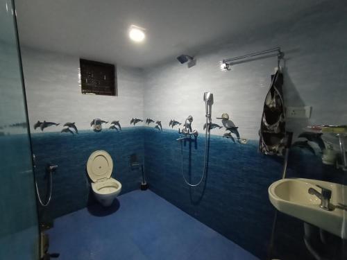 a bathroom with a shower and a toilet and a sink at Jerone's Home Stay in Majorda