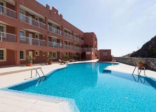 a large swimming pool in front of a building at Sunshine in Costa Calma