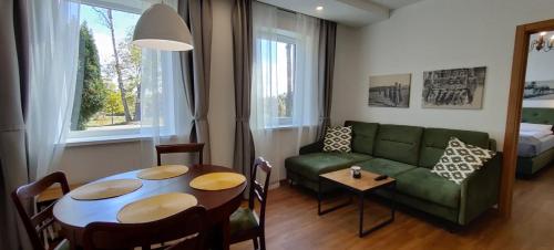 a living room with a green couch and a table at Exceptional Pogegen Apartment in Pagėgiai