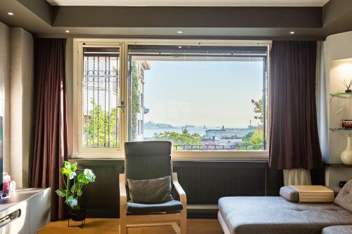 ein Schlafzimmer mit einem Fenster, einem Stuhl und einem Bett in der Unterkunft with Fascinating Bosphorus View in Besiktas in Istanbul