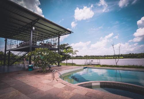 budynek z basenem obok jeziora w obiekcie Starling River Resort Dandeli w mieście Dandeli