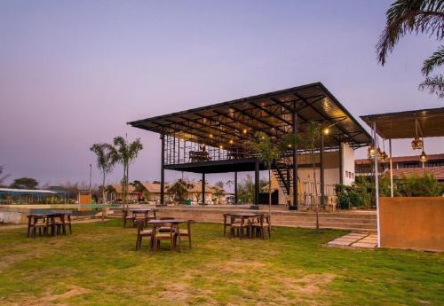 a group of tables and chairs in front of a building at Starling River Resort Dandeli in Dandeli