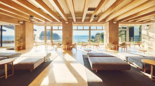 a large room with benches and tables and windows at il azzurri in Nishiizu