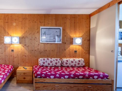 ラ・プラーニュにあるStudio La Plagne, 1 pièce, 3 personnes - FR-1-353-9の木製の壁の客室で、ベッド1台とソファが備わります。