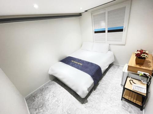 a small bedroom with a bed and a window at The Road Hotel in Seoul