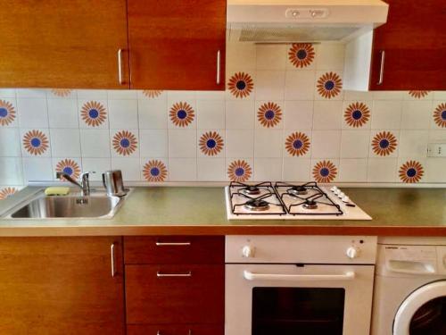 a kitchen with a stove top oven next to a sink at Residence Baia degli Sciti in Torre a Mare