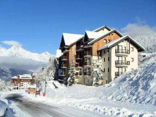 a building on a snow covered mountain with a road at Chalets Du Thabor - 2 Pièces pour 4 Personnes 46 in Modane