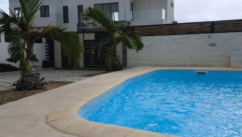 a large blue swimming pool in front of a house at Vanz Villa in Mont Choisy