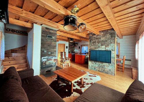a living room with a couch and a tv and a table at Chata Musica in Nižné Malatíny