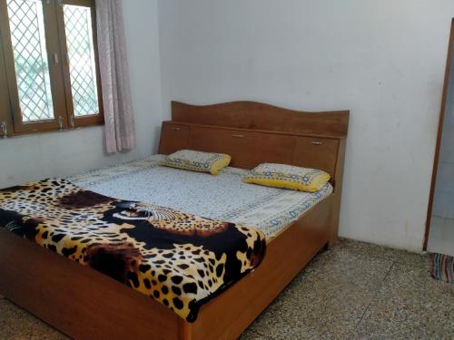 Cama en habitación con colcha estampada de leopardo en Mount Valley Mama Cottage, en Rishīkesh