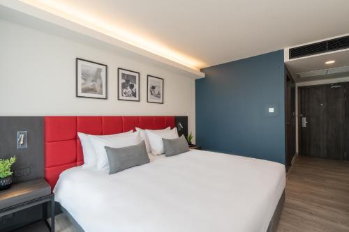a bedroom with a large bed with a red headboard at Travelodge Phuket Town in Phuket Town